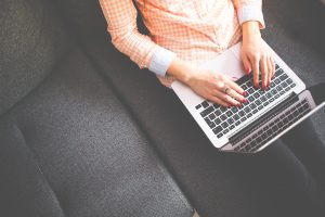 lady sat with laptop writing a blog