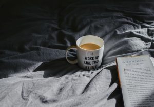 mug of coffee on bed covers