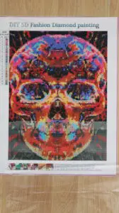 multi-coloured skull diamond painting being completed as a hobby