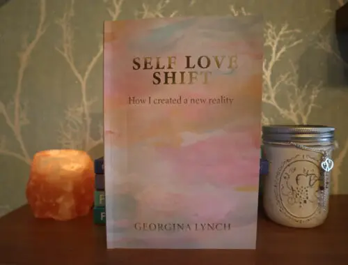 self love shift book on a shelf next to jar tealight holder and Himalayan rock salt tealight holder