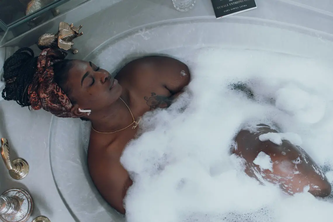 person relaxing in a bubble bath for self-care