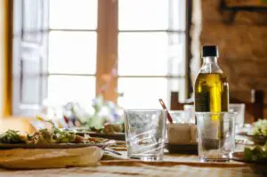 olive oil on a table with a few food and kitchen items