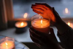 lit candle covered by a hand