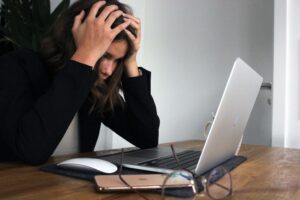 woman at desk stressed with laptop - deal with the Sunday Scaries