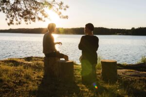 two people speaking in front of a lake: How to Support Family and Friends with Depression