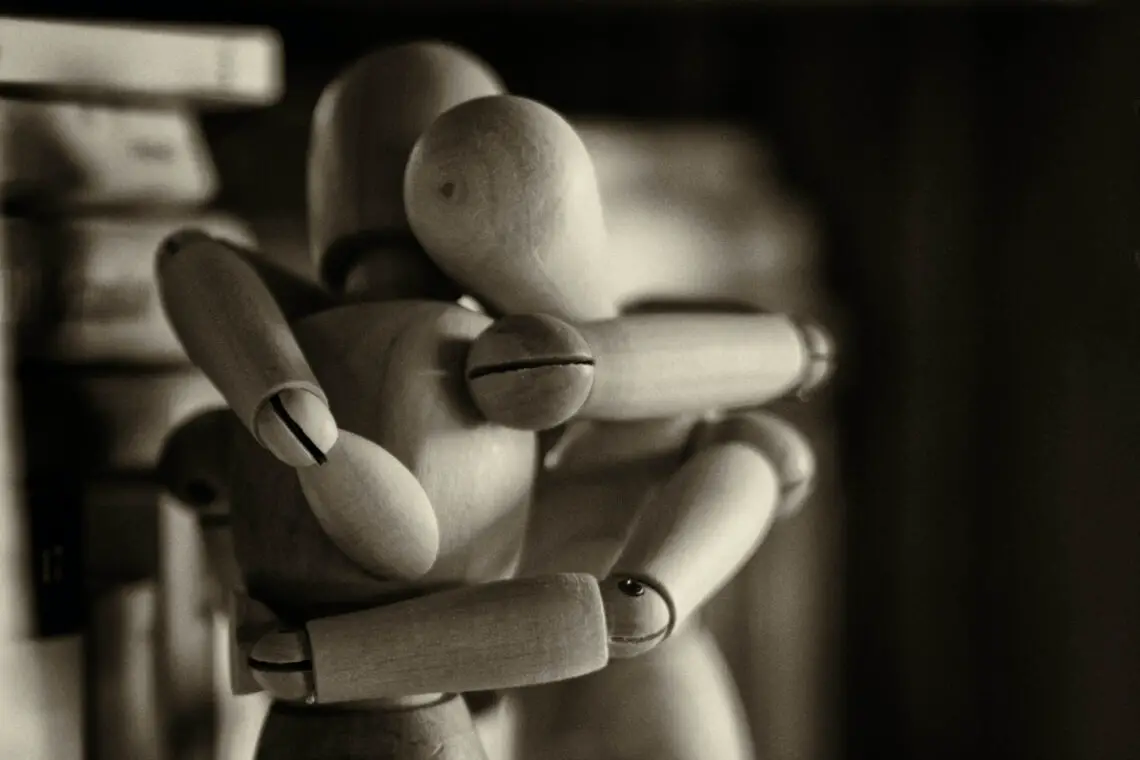 two wooden models hugging