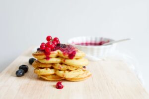 pile of heart-shaped pancakes with berries and sauce: family-friendly Valentine's Day activities