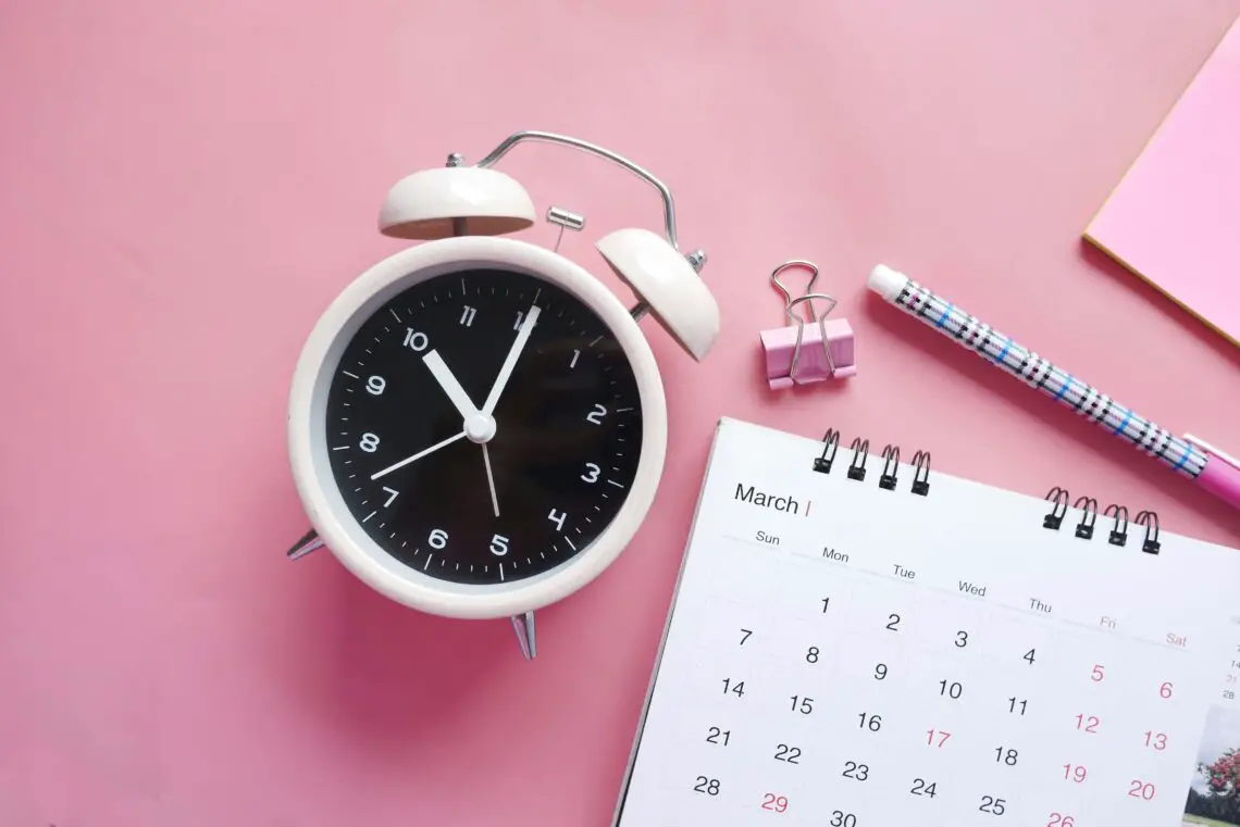 alarm clock with calendar, bullclip and pen