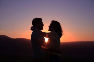 silhouette of two people with a sunset, arms around each other: strengthen your relationship after kids