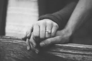 a couple holding hands with a wedding ring on a finger